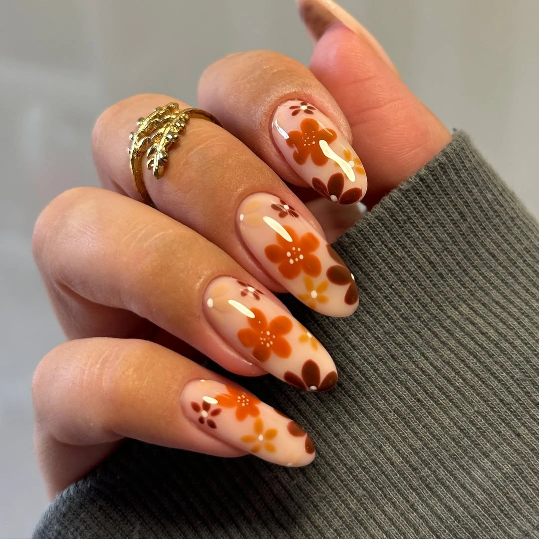 nude almond nails with orange floral clusters