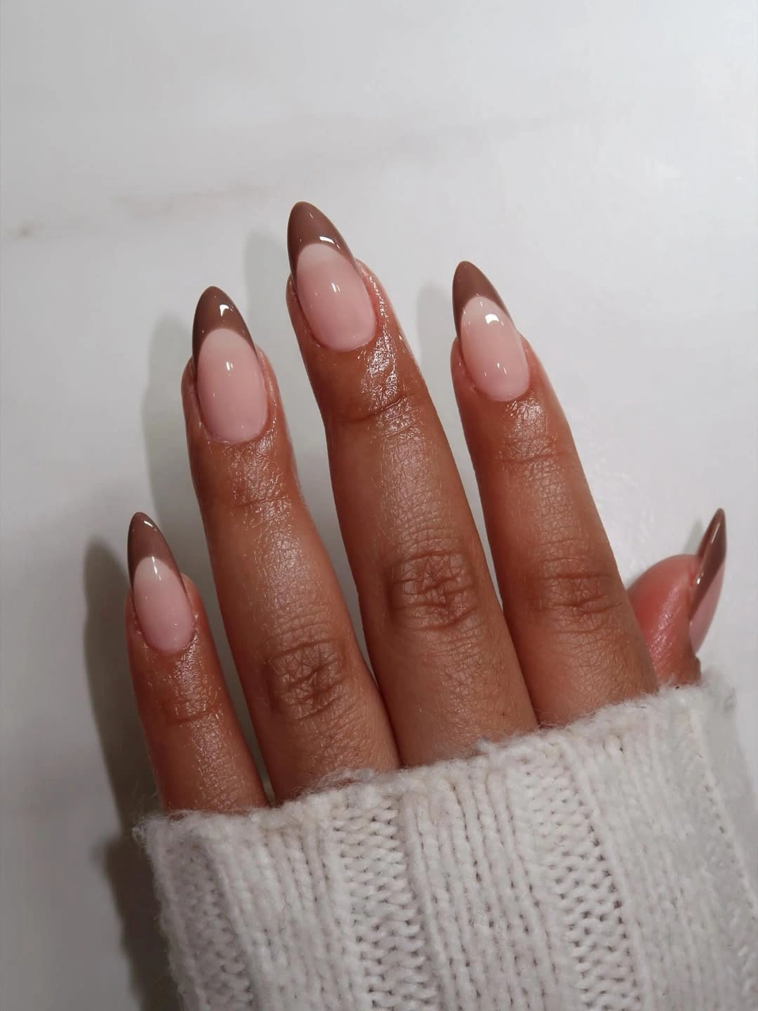 Sheer pink almond nails with chocolate French tips
