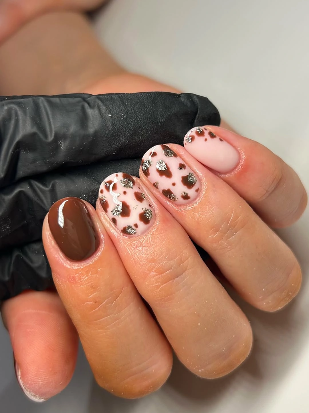 Short brown nails with spotted pink accents