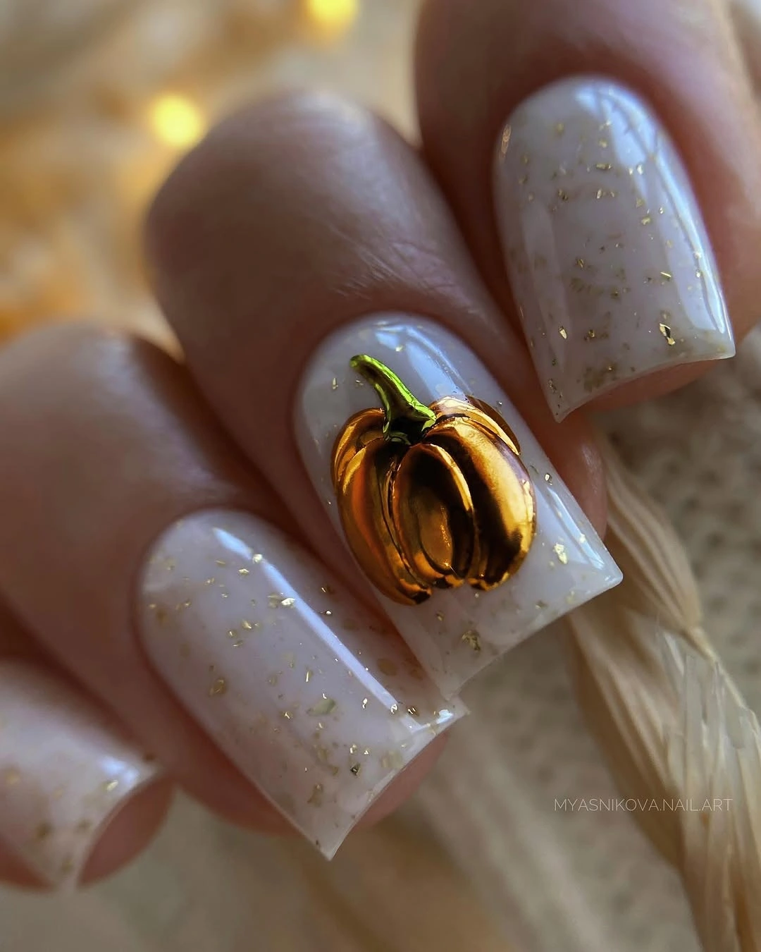 Milky white short nails with gold pumpkin accent