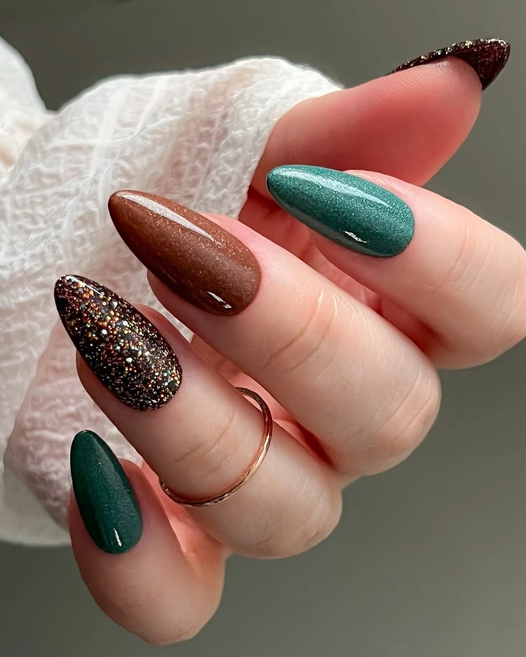 Dark green almond nails with one glitter accent