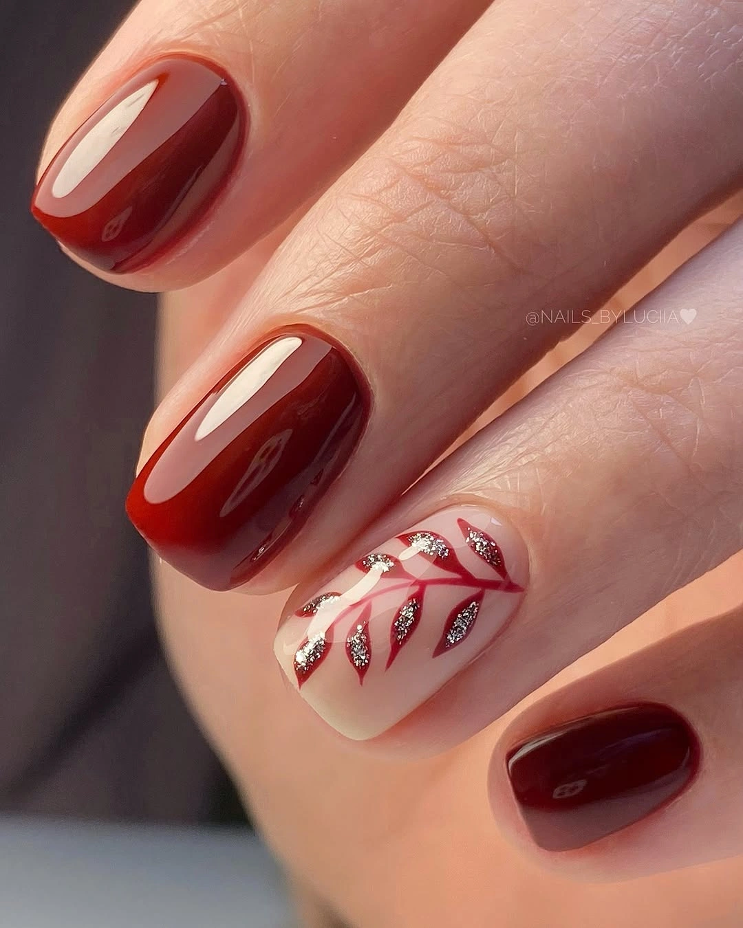 Short dark red nails with pale leaf accent
