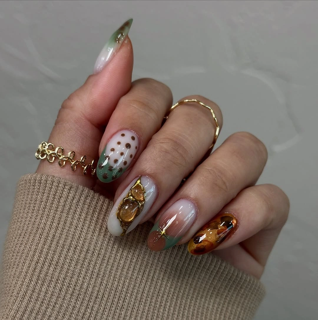 Translucent nude nails with green tips and amber accents