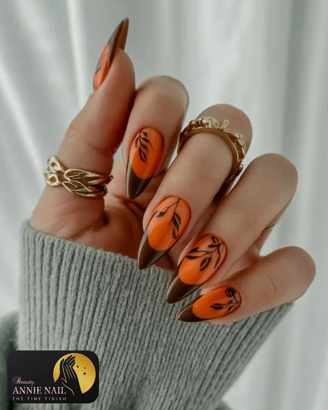 Long stiletto orange nails with black seasonal line art