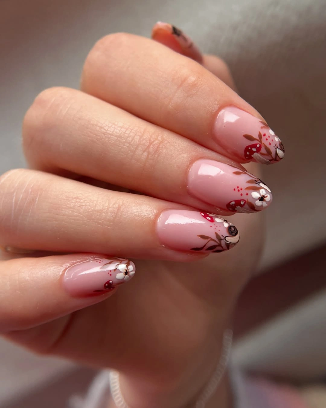 Medium almond blush nails with delicate brown floral lines