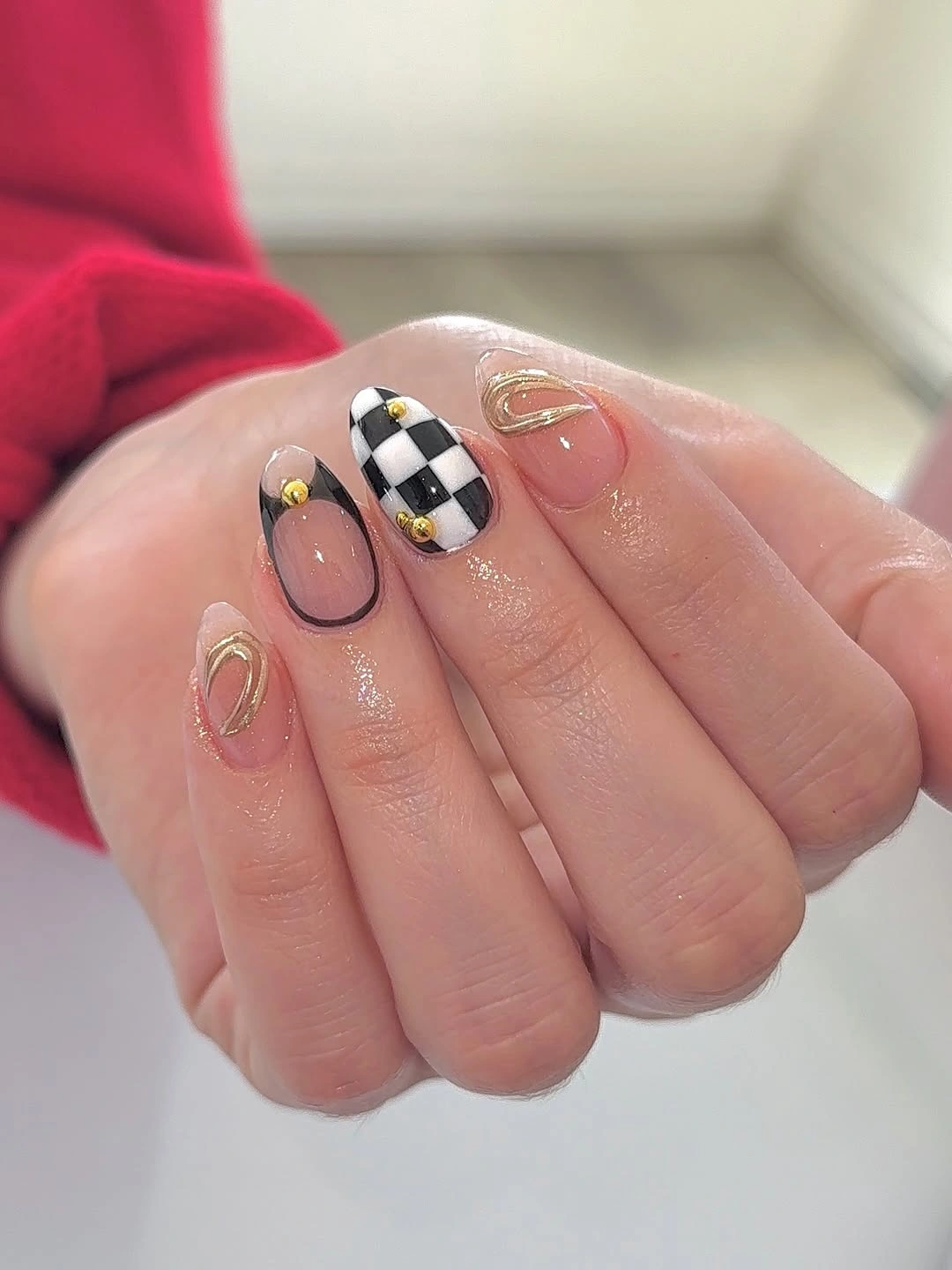 Medium square cream nails with one checkerboard and gold accent