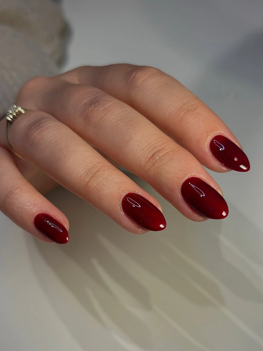 Short almond nails in glossy deep burgundy polish
