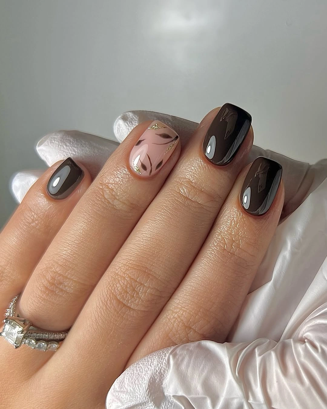Short squoval office nails with dark neutrals and one abstract accent