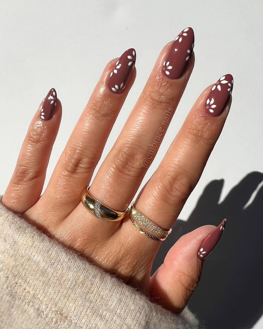 Long almond brown nails with tiny white floral accents