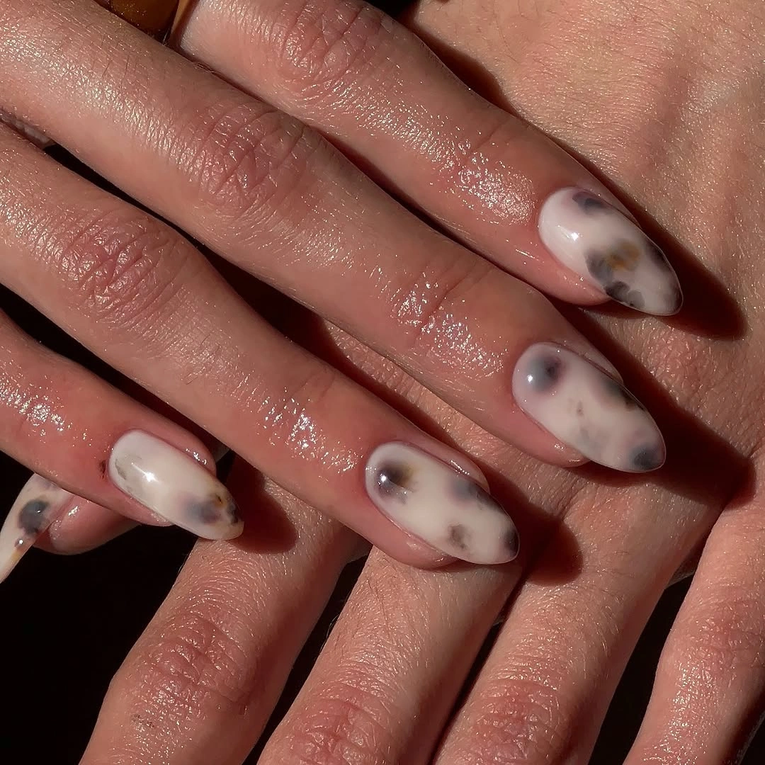 Long almond nude nails with flowing espresso brown swirls