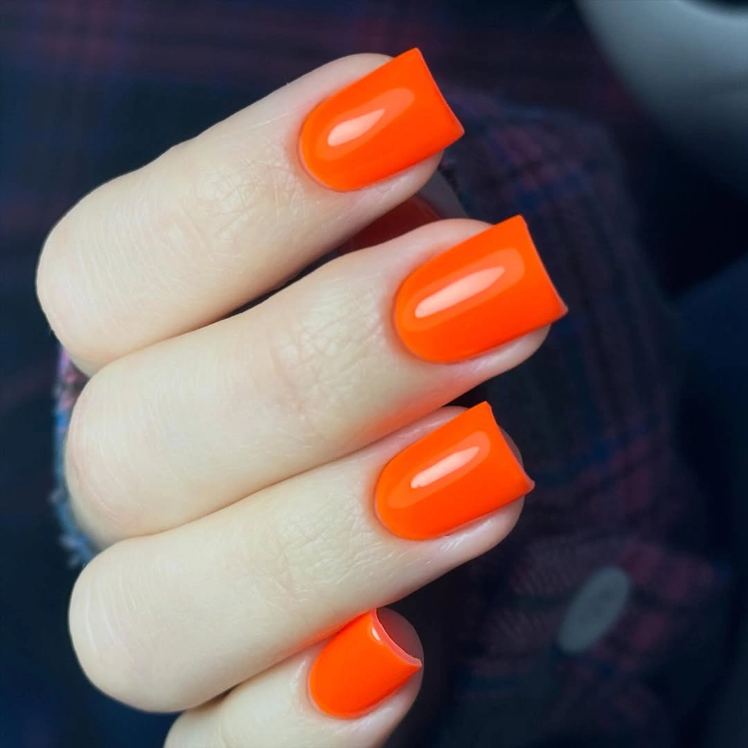 Bright glossy orange nails on a medium square shape