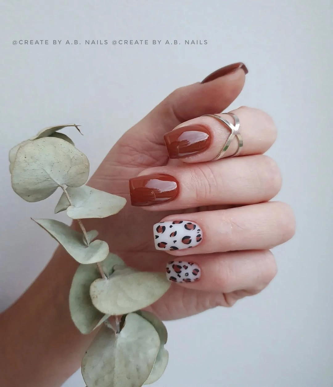 Nude square nails with brown French tips and leopard accents
