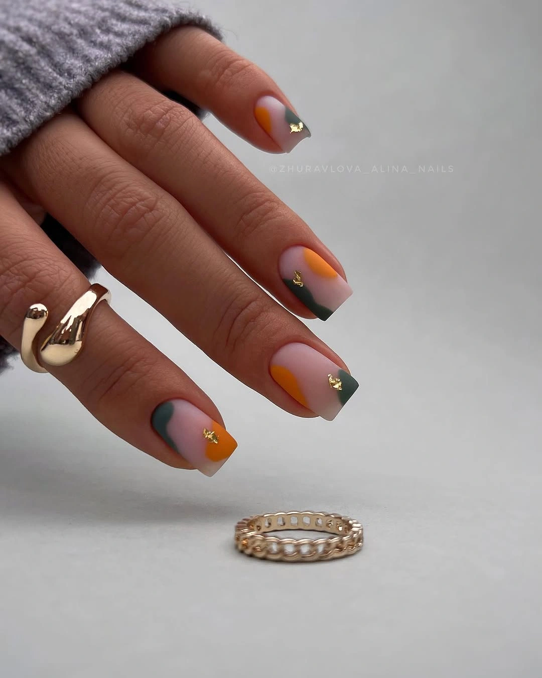 Gray square nails with small orange and yellow accents