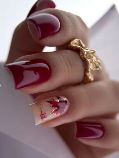 Burgundy square nails with one pale floral accent