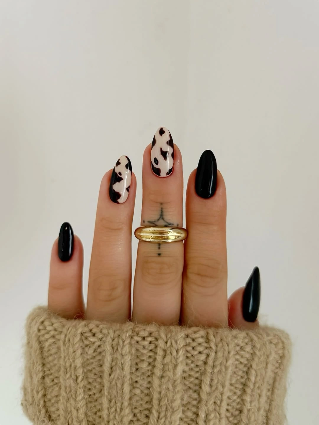 Long stiletto nails with solid black tips and white spotted accents