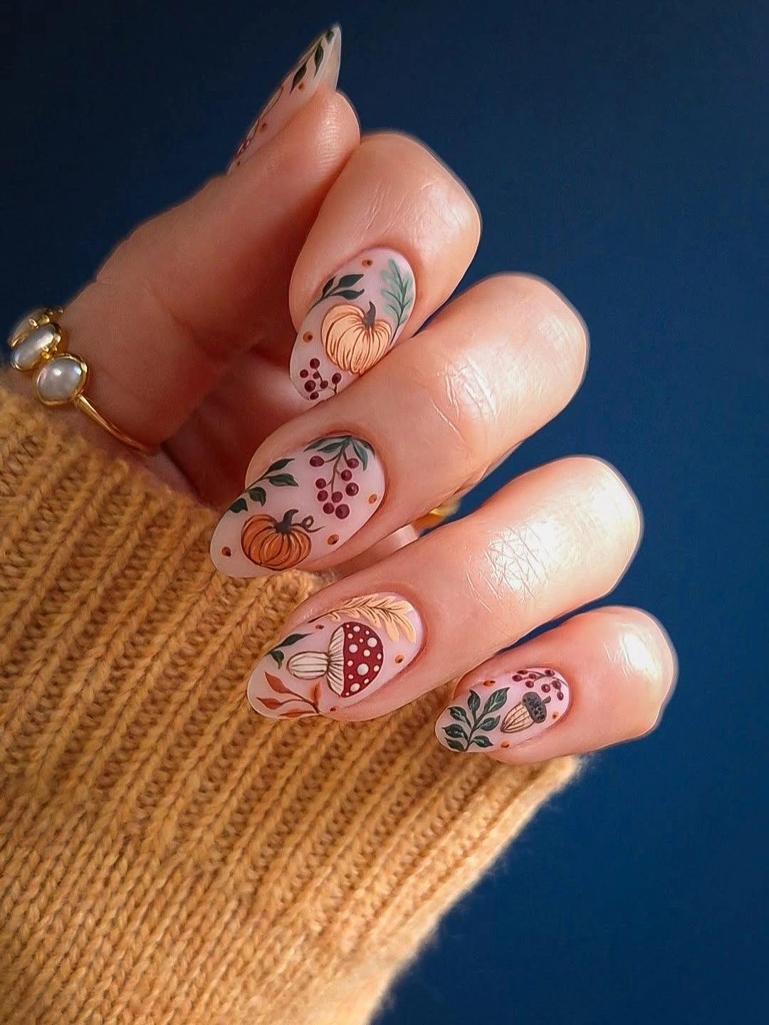 Long almond nude nails with warm brown orange and black botanical linework