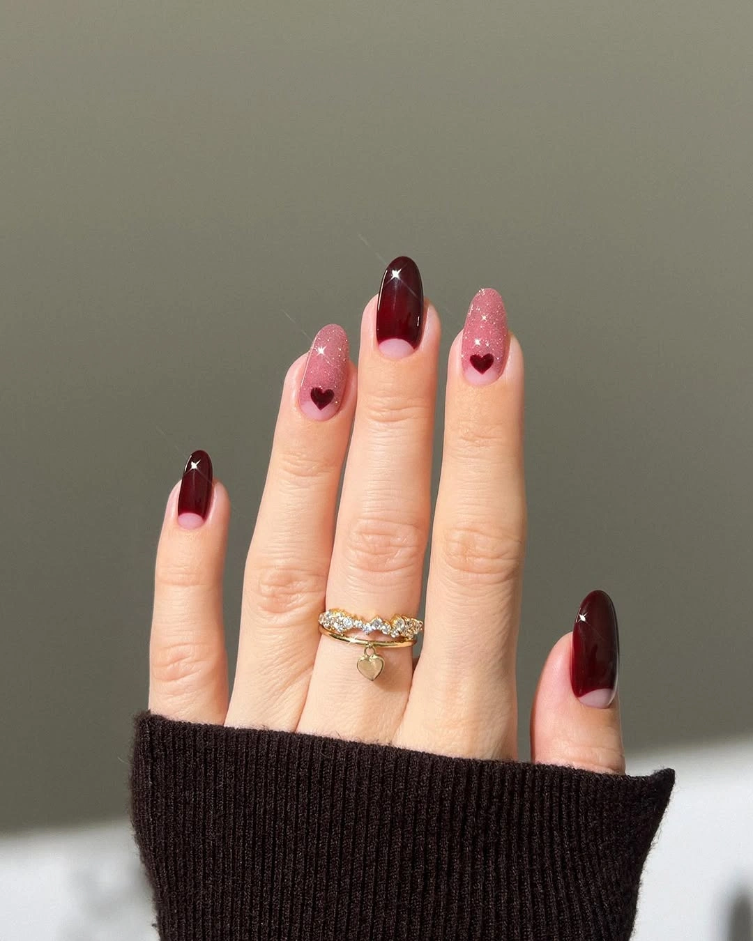 Long coffin burgundy French nails with tiny heart accents on a pale base