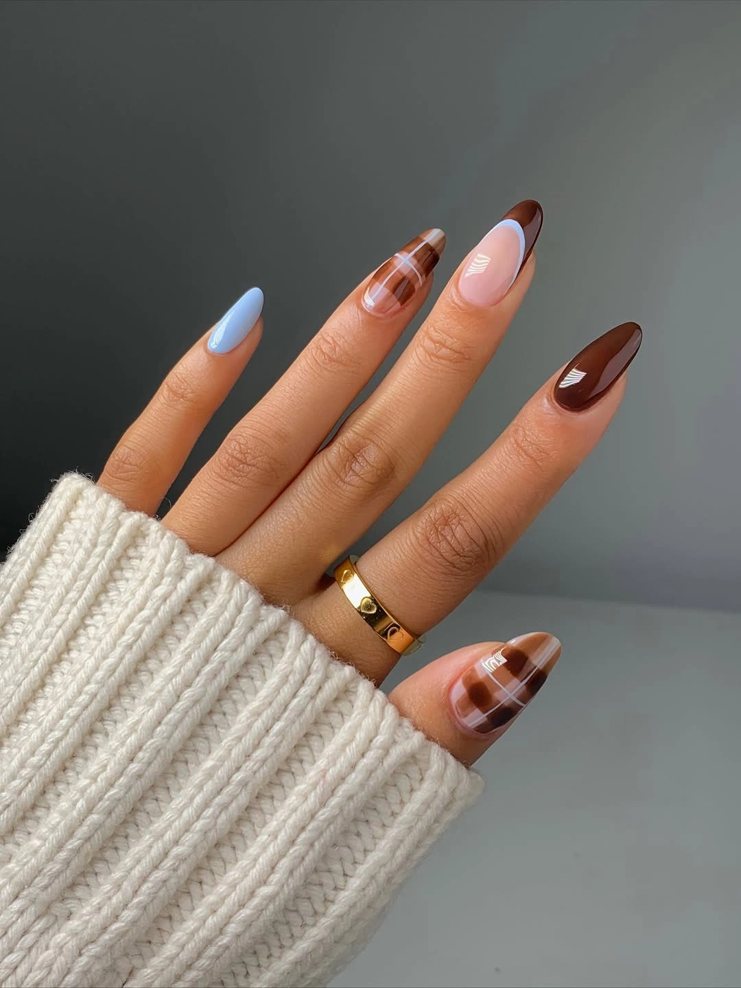 Long almond nails with blue tips brown sections and a tortoiseshell accent
