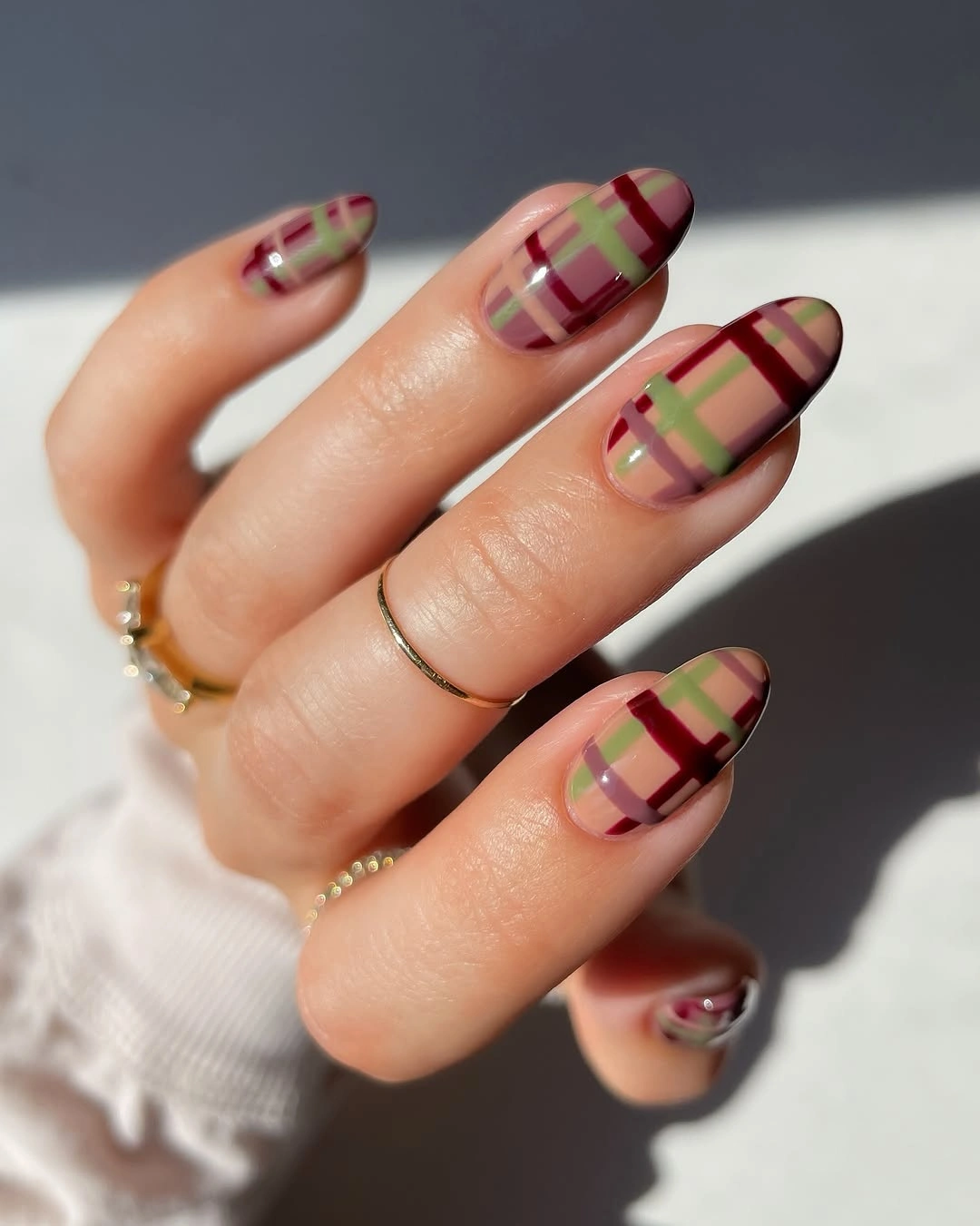 Medium almond nails with burgundy olive and blush plaid lines