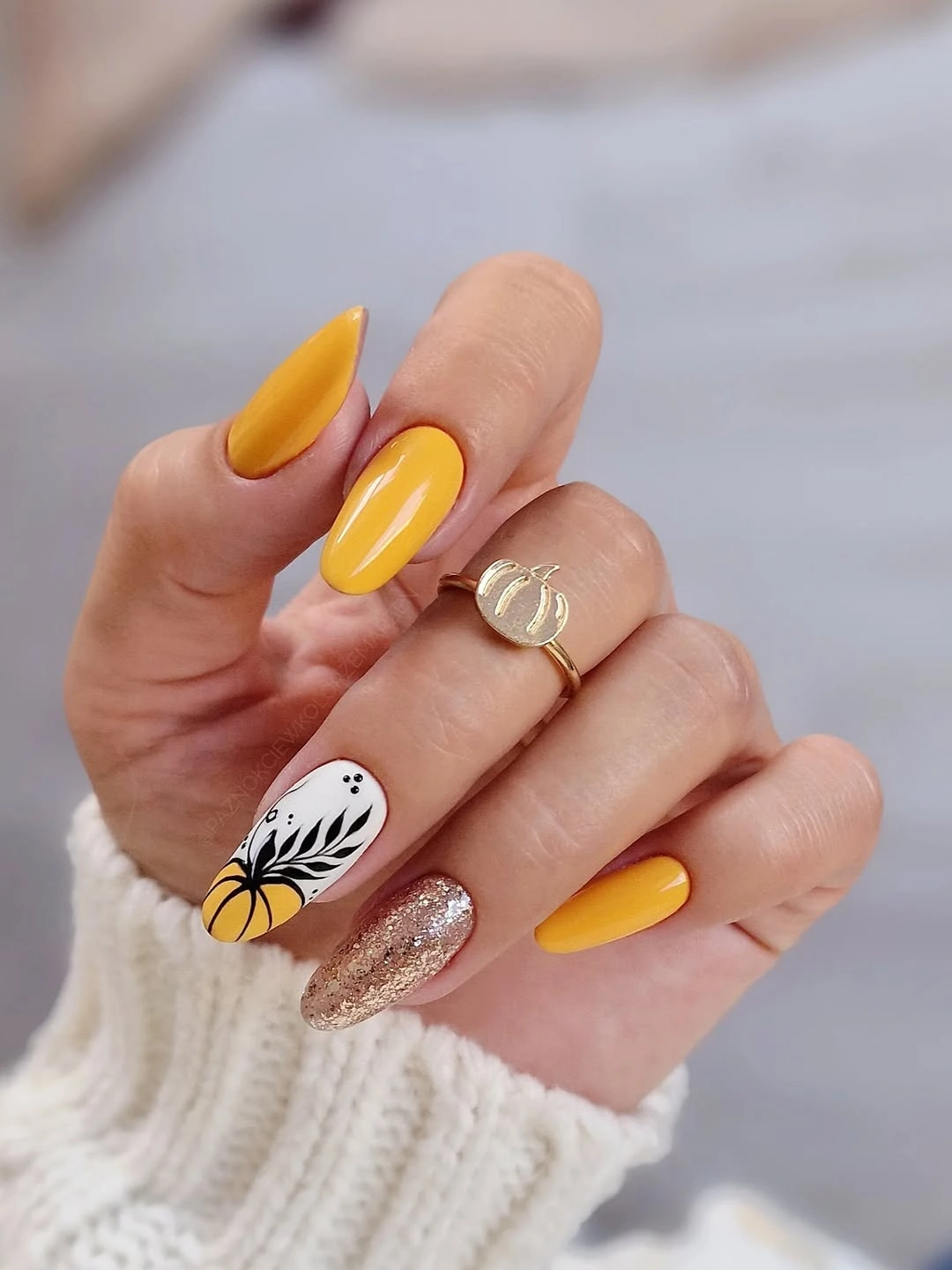 Long almond yellow tips with white floral detail and silver glitter accent