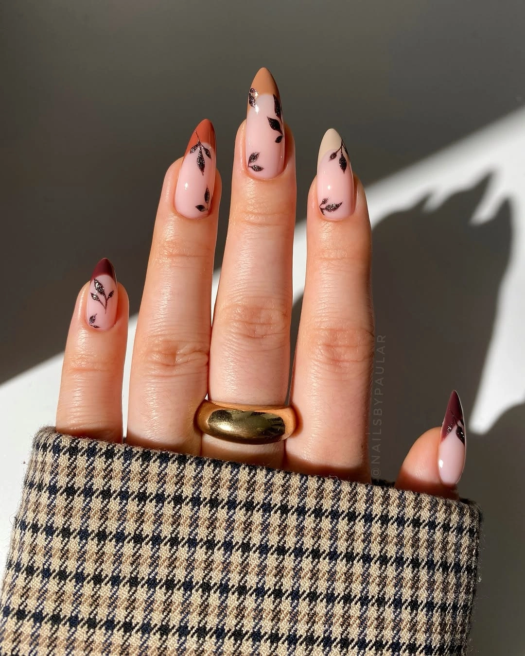 Medium almond nude nails with black orange and brown curved printed details