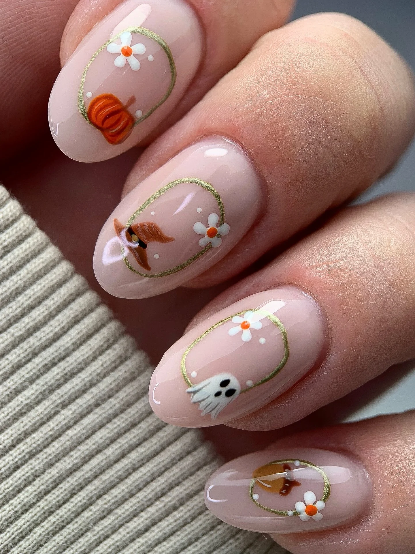 Short oval sheer pink nails with tiny flowers green stems and pumpkin accents