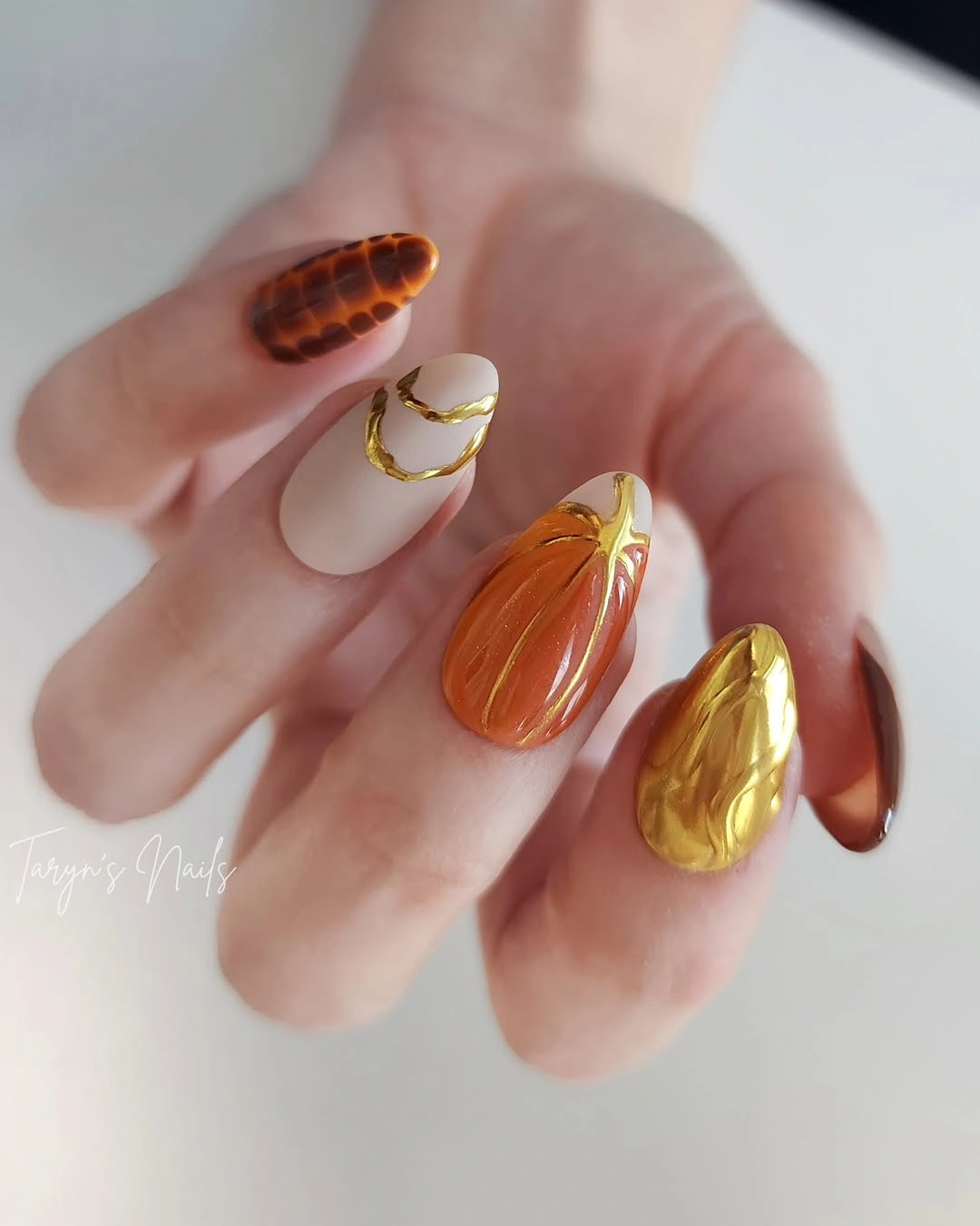 Amber tortoiseshell almond nails with gold line accents