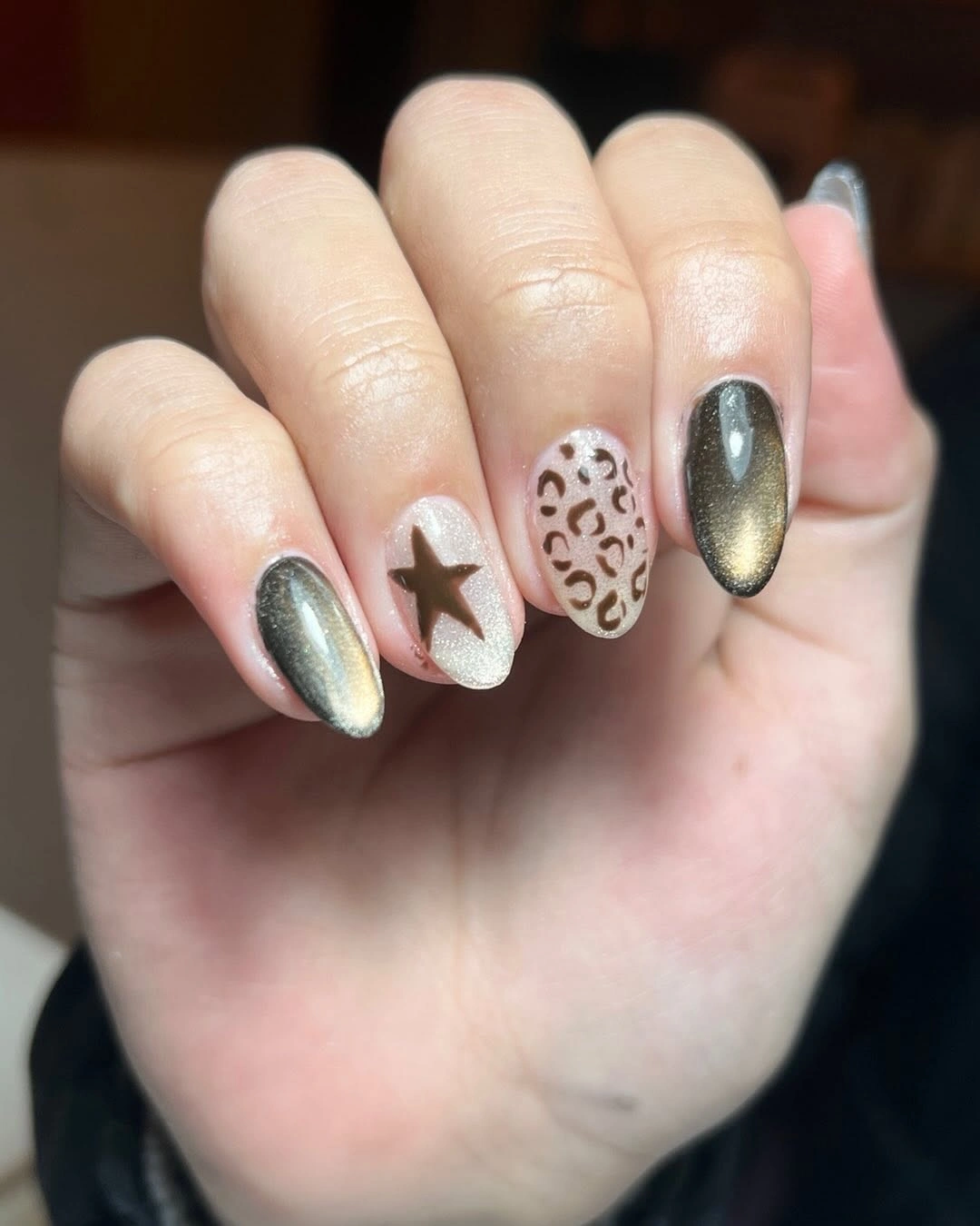 Neutral nails with metallic olive spots and a star accent