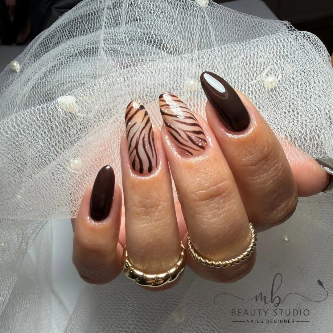 Chocolate almond nails with curved brown leaf-like linework