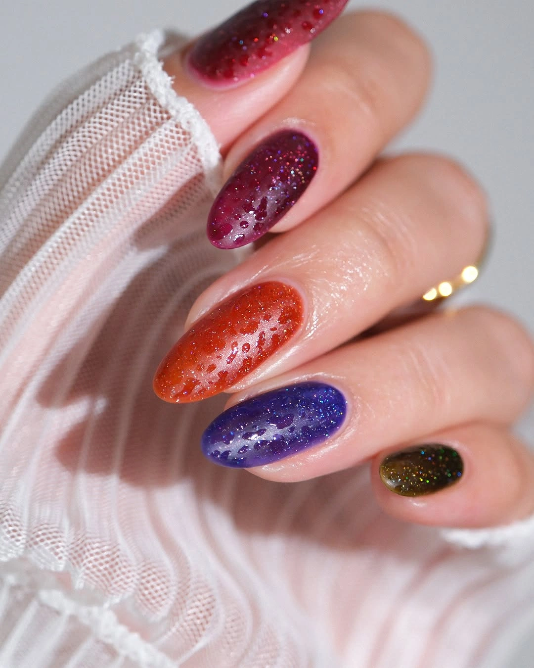 Mixed jewel glitter almond nails in red purple blue and orange