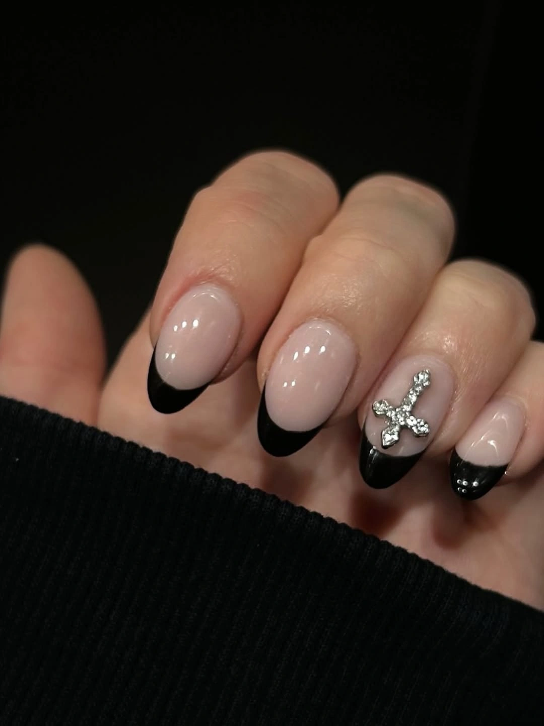 Blush nails with black French tips and jeweled bow accent