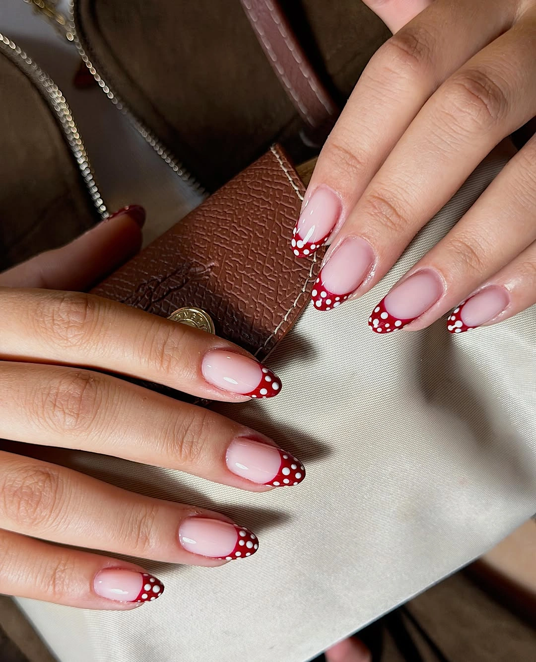 Pink almond nails with burgundy dotted French tips