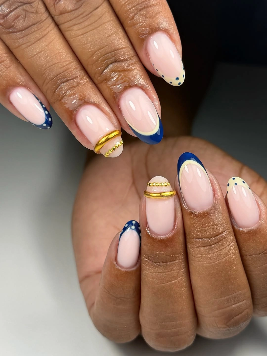 medium almond blush nails with blue and gold edges