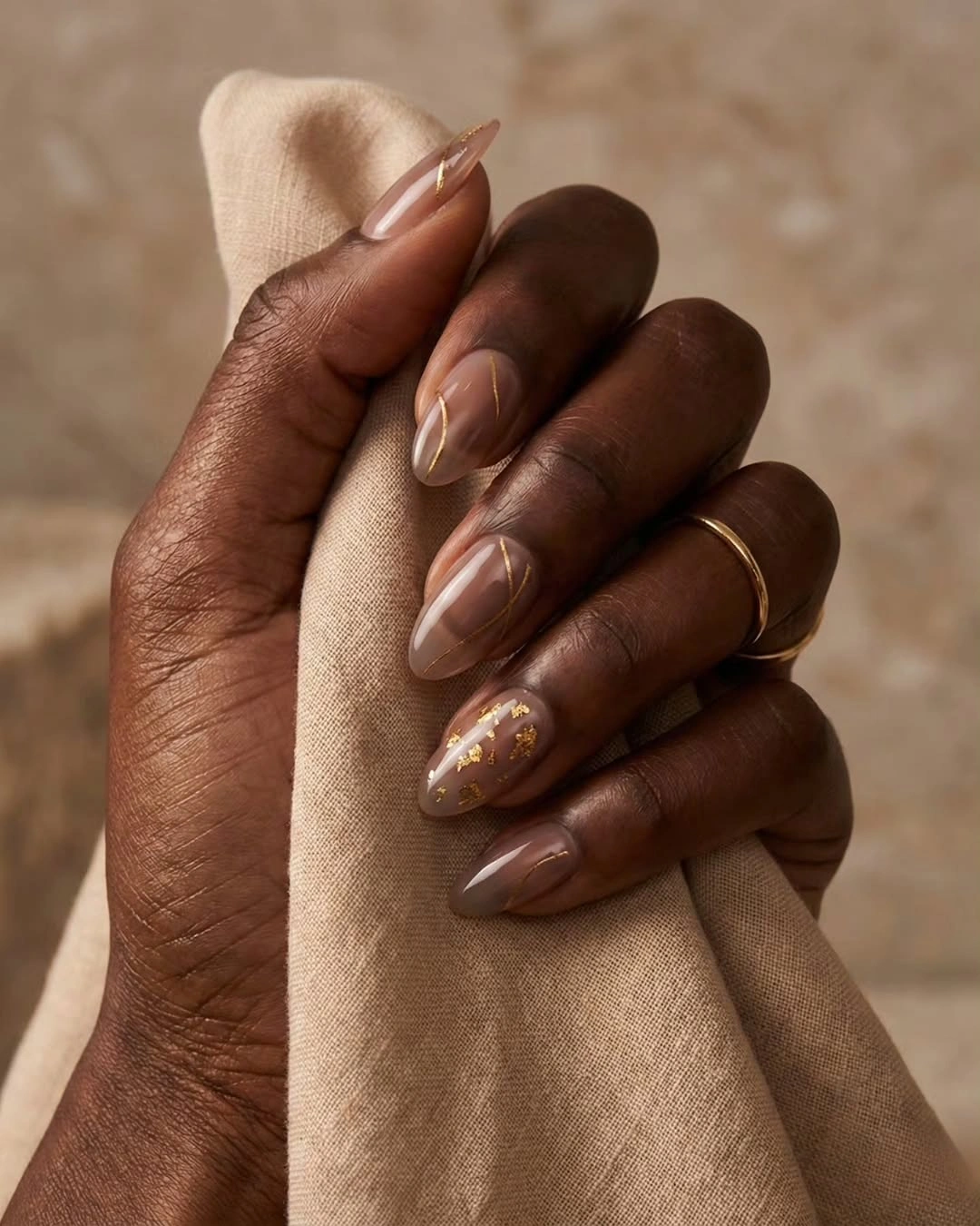 Medium almond warm brown nails with delicate gold floral accents