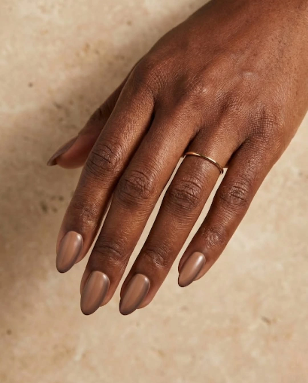 Medium almond nails in a glossy warm nude brown shade