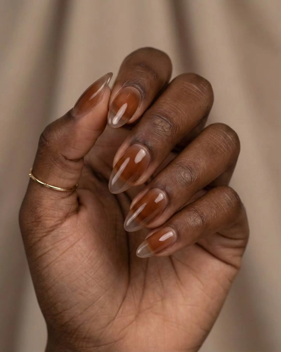 Medium almond caramel nails with glossy chocolate brown abstract swirls