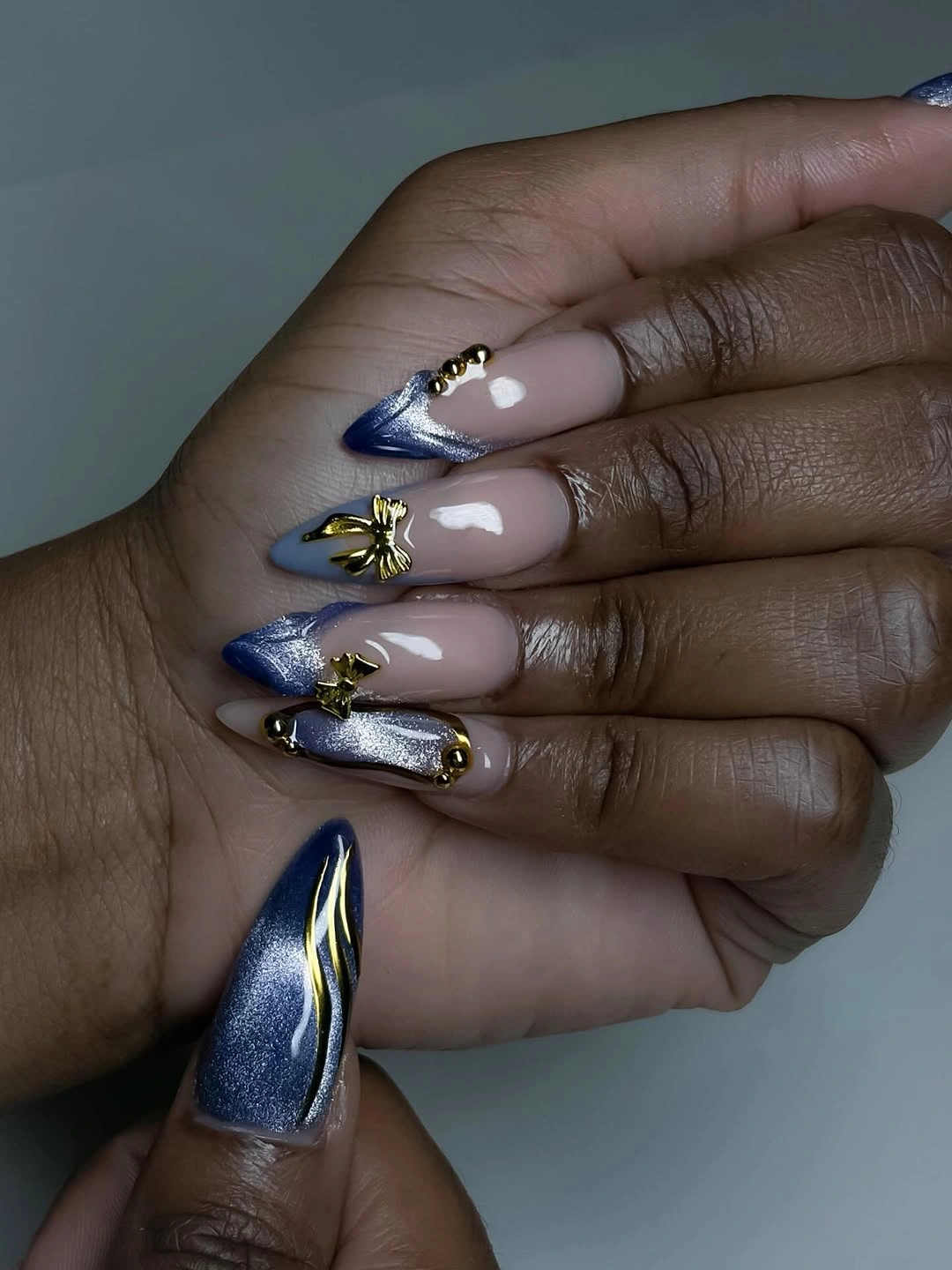 Long navy stiletto nails with silver glitter and gold white linework