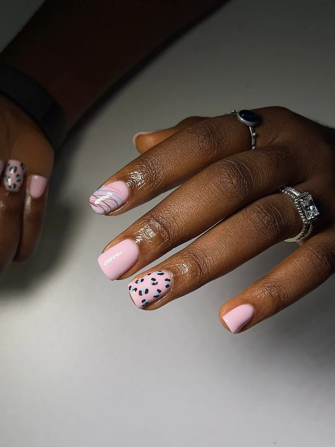 Short square pink and cream nails with chocolate blocks and spotted accent