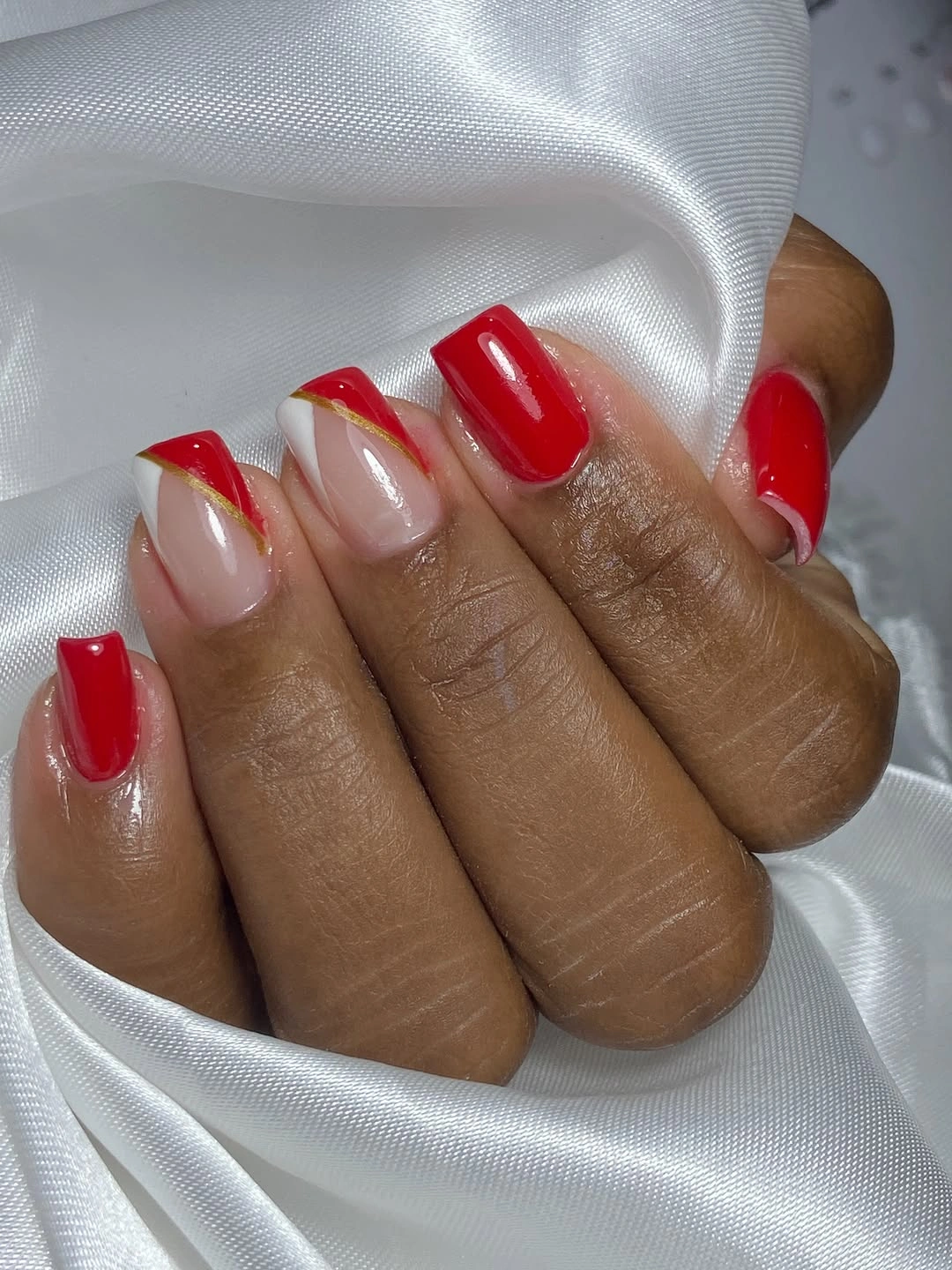 Short square sheer pink nails with bright red and white diagonal French tips