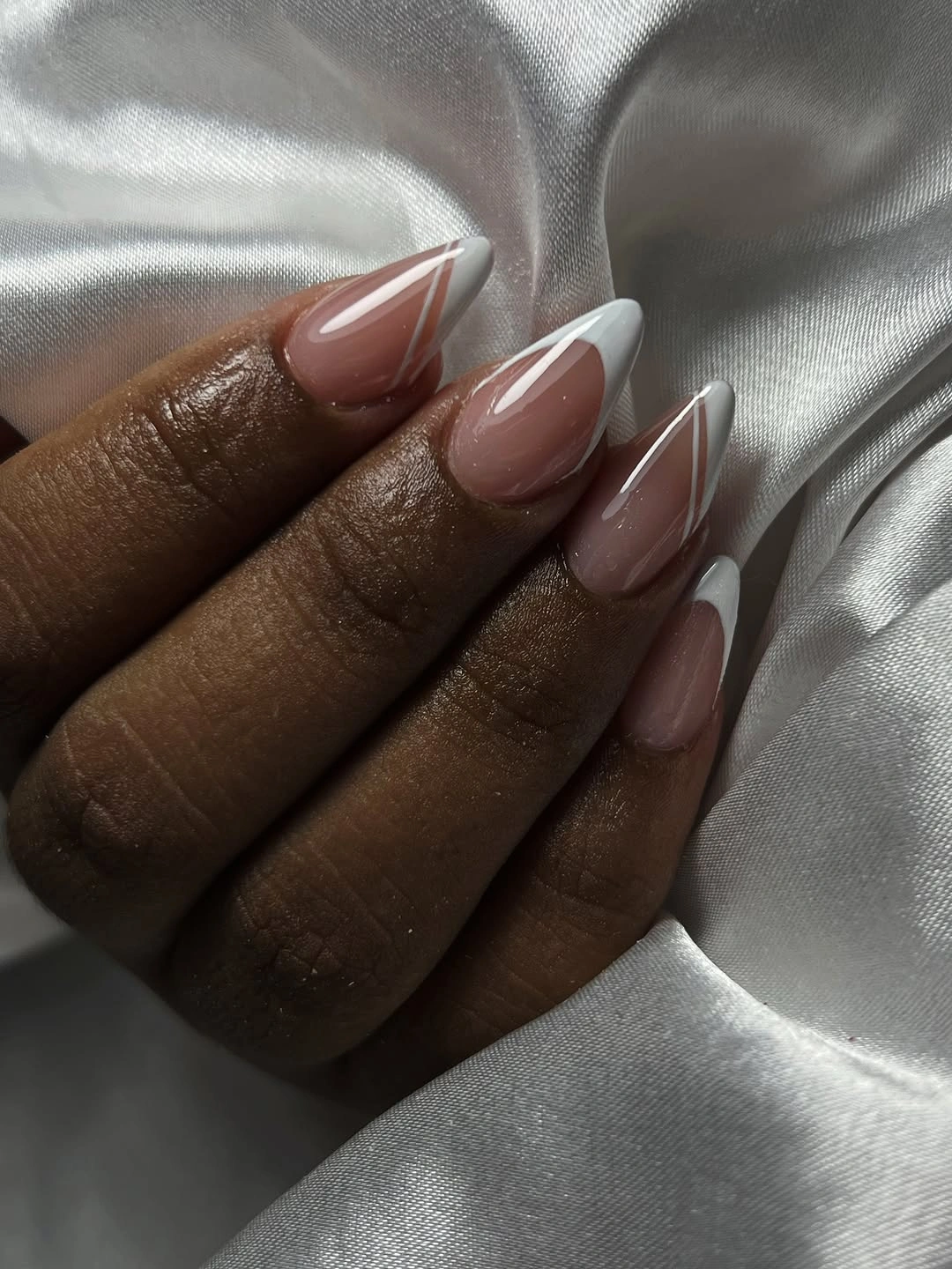Long almond sheer nude nails with white French tips and reflective outlines