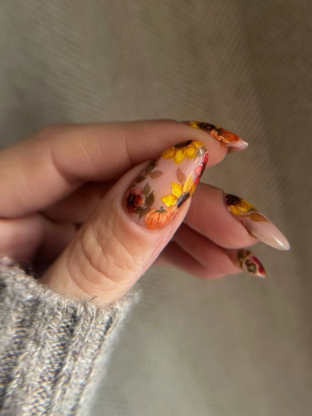 Long nude nails with warm yellow orange floral tip art