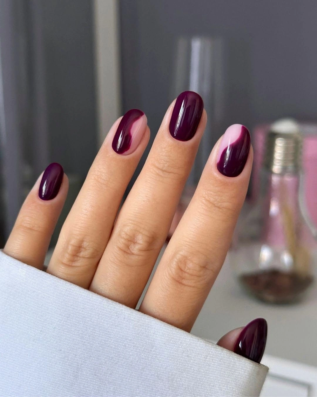 Deep plum almond nails with diagonal reflective light streaks