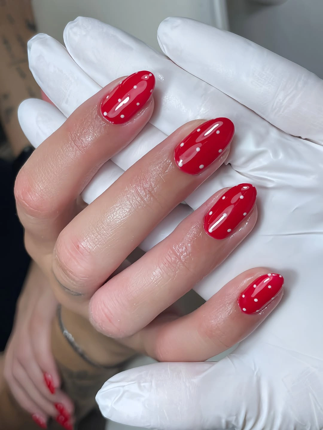 Short scarlet almond nails with fine white dotted leafy details