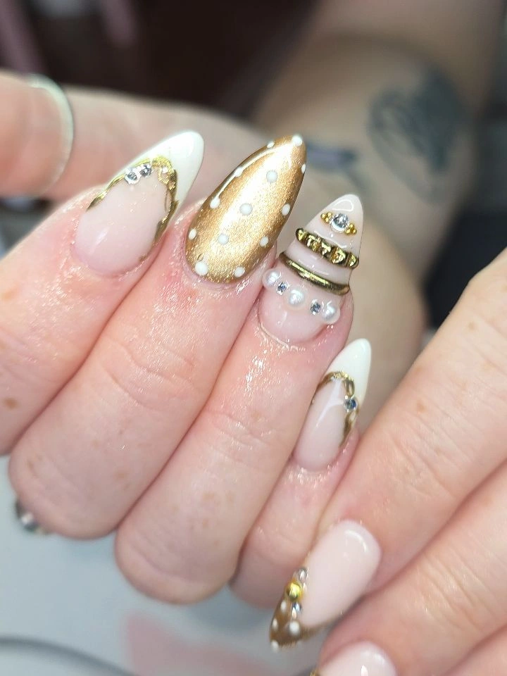 Long ivory stiletto nails with gold glitter and gem details