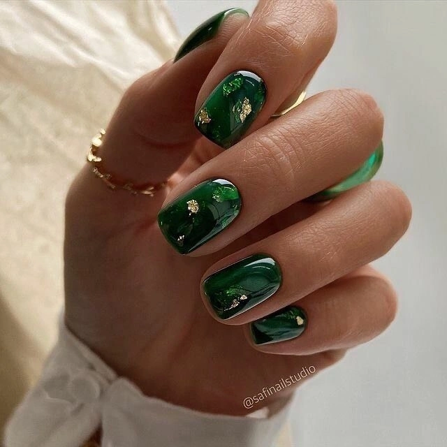 Medium emerald oval nails with scattered gold foil accents