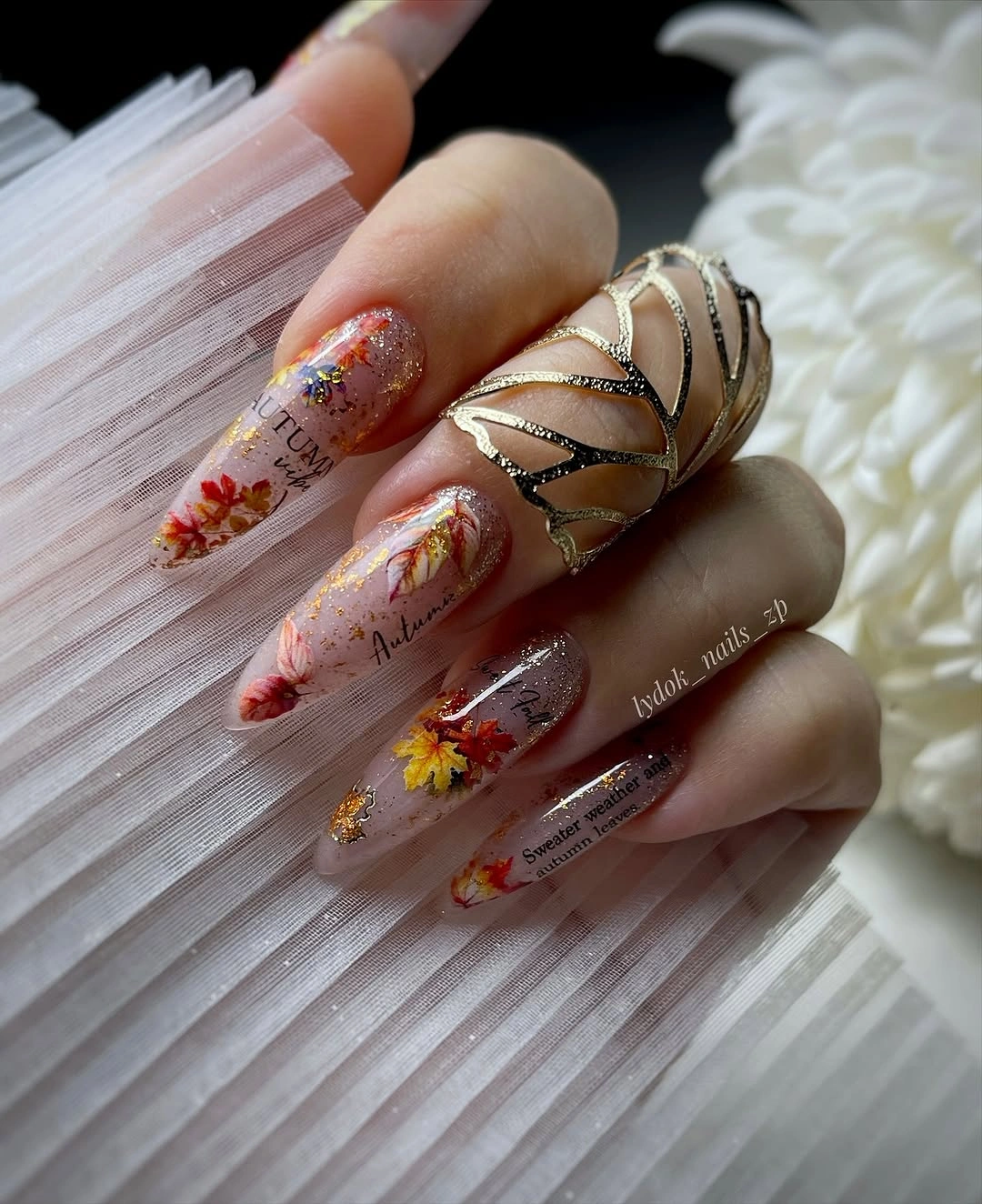 Long sheer peach square nails with tiny floral and metallic accents