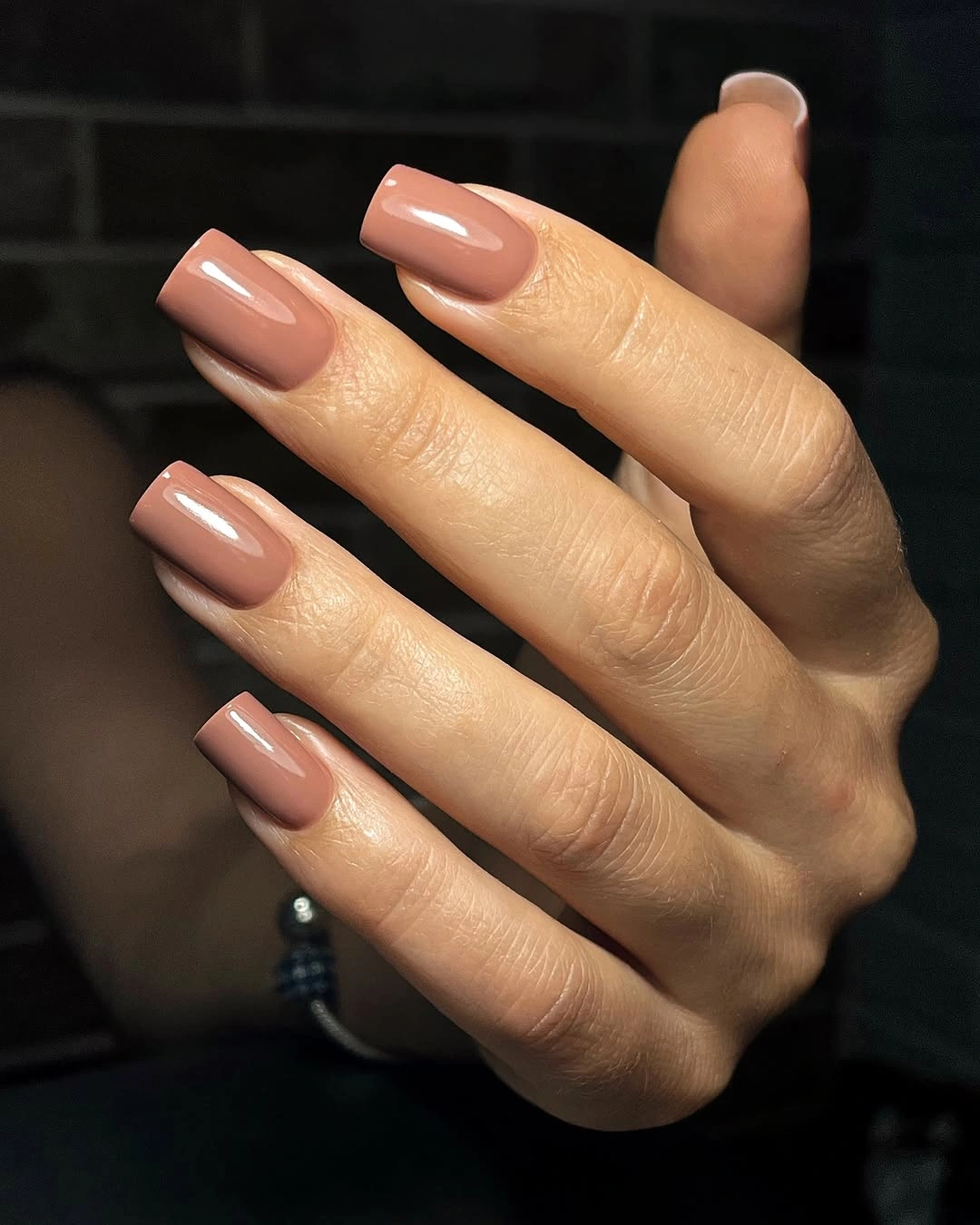 Medium square nails in a uniform glossy warm nude brown