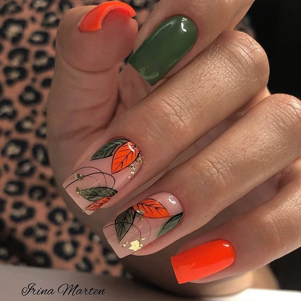 Olive oval nails with orange leaf accents on nude nails