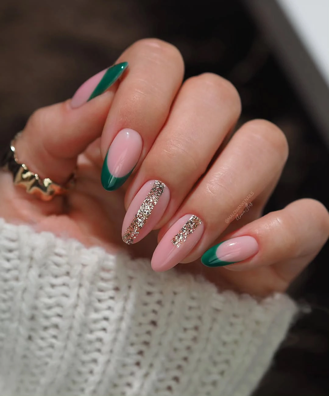 Long pink almond nails with deep green tips and glitter accents