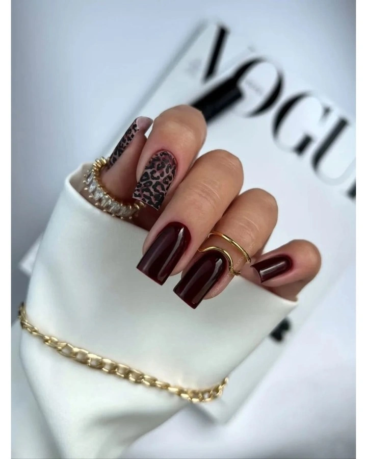 Long glossy burgundy square nails with one patterned feature nail